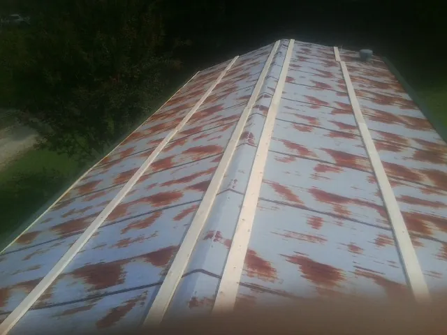 Rusted metal roof panels with new wood purlins before replacement — Storm Damage Roof Repair in Millbury by Roofing Brothers