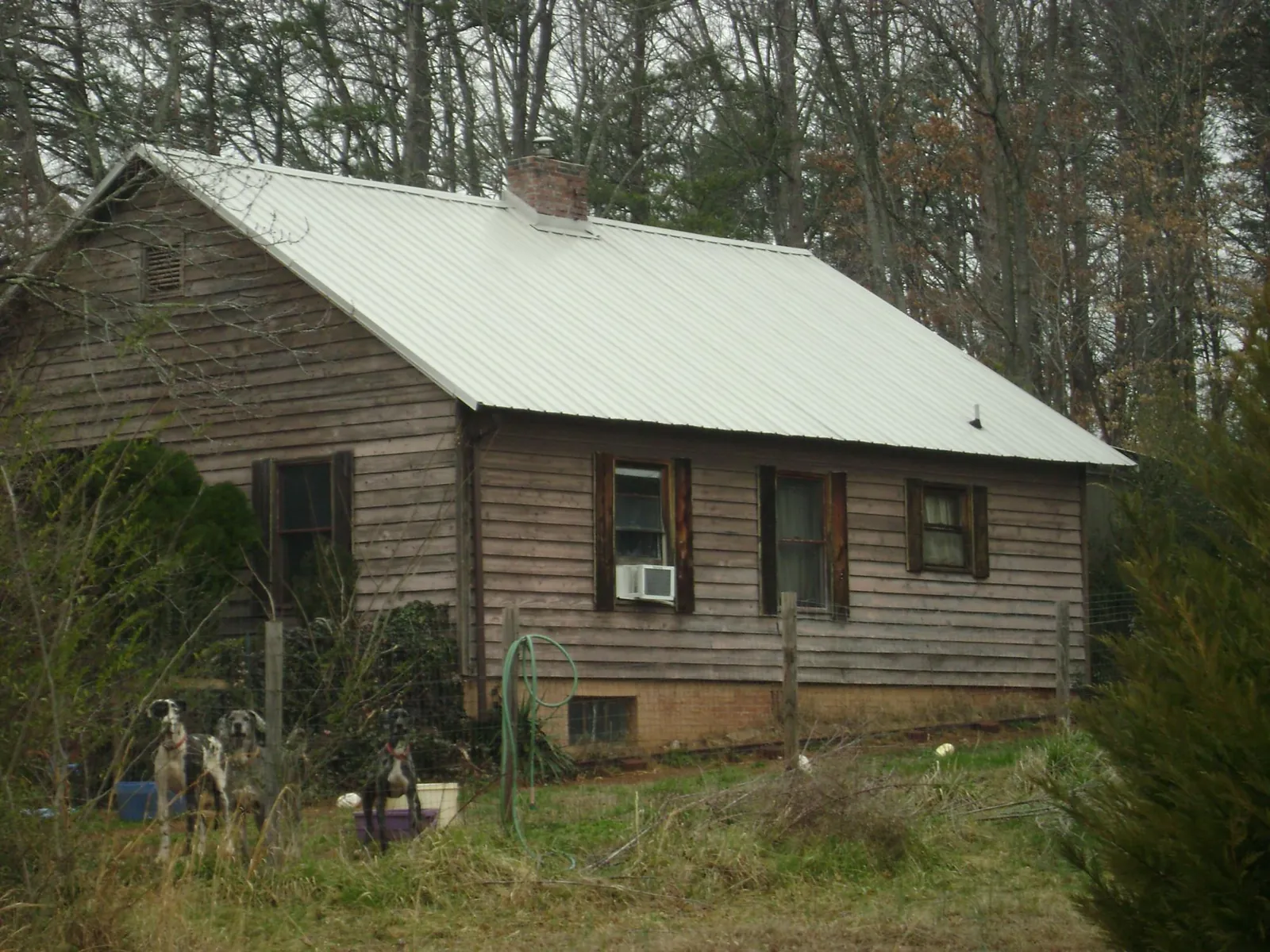 White metal roof on an old wood sided farmhouse, from a Metal Roof Installation job in Millbury